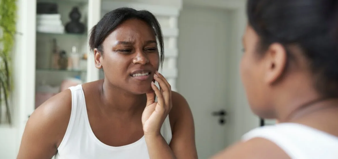 woman in the bathroom having a strong toothache or bruxism