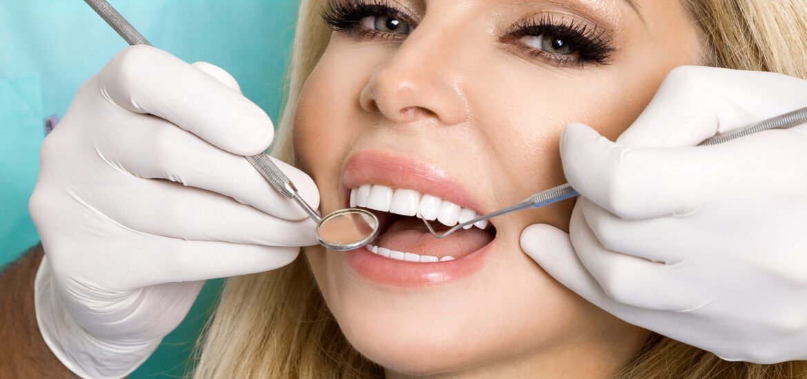 Beautiful woman with beautiful white veneers sitting on a dental chair.