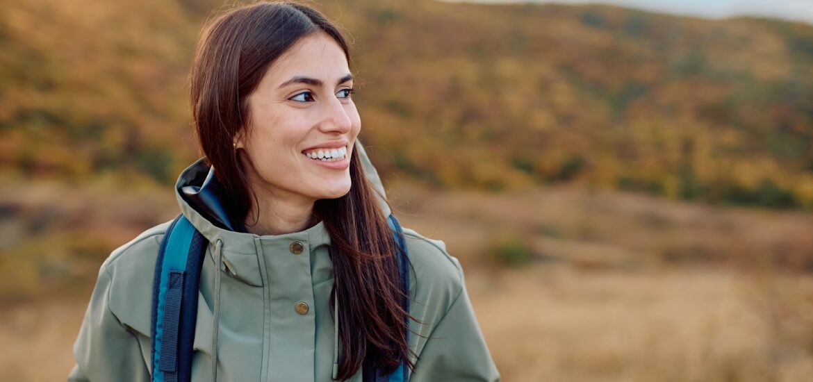happy woman hiking outdoors, perfect white smile